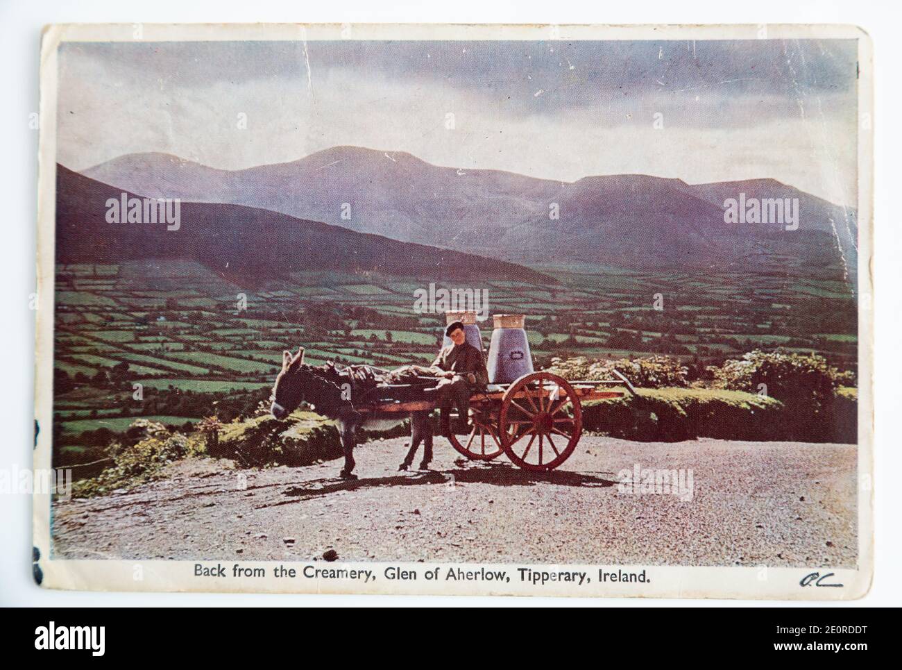 Alte Postkarte, die einen Jungen auf einem Wagen mit Milchkännern zeigt, Tipperary, Irland. Veröffentlicht in 1962. Stockfoto