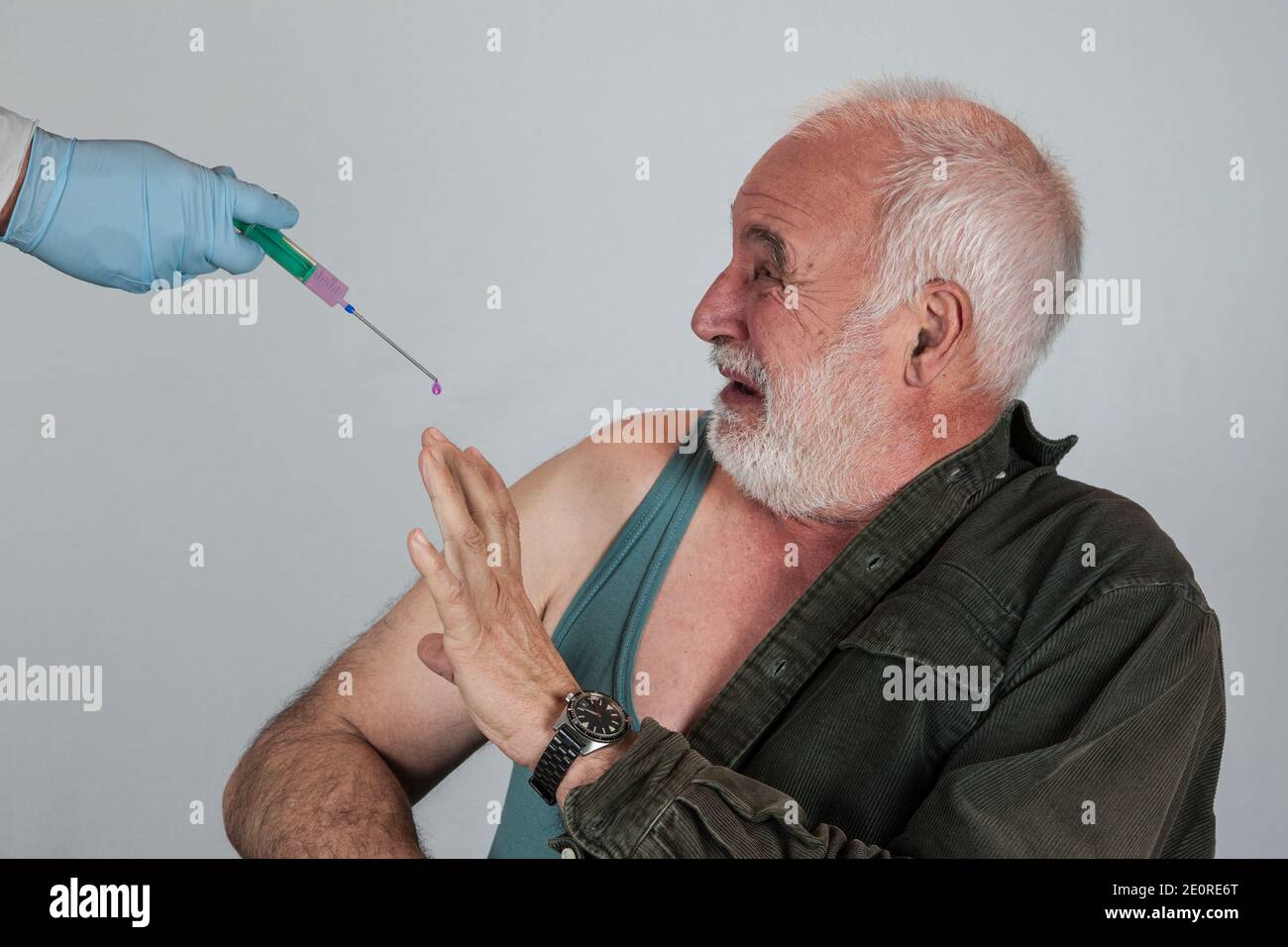Ein älterer Mann hat Angst vor der Coronaimpfung und den möglichen Nebenwirkungen der Immunisierung. Stockfoto