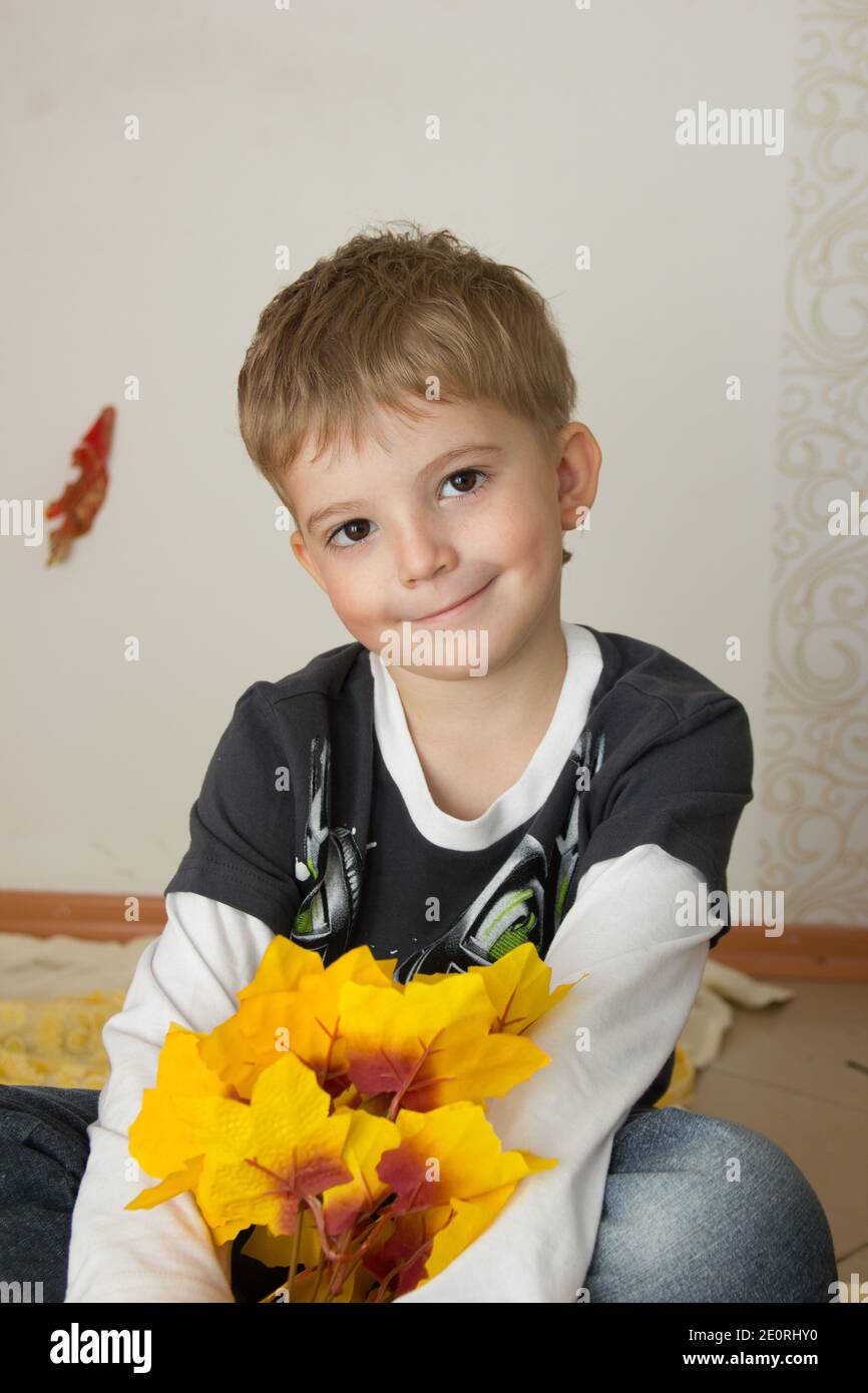 Porträt eines schönen Jungen mit einem europäischen Auftritt. Das Kind neigt seinen Kopf, lächelt und lacht. Kinderemotionen der Freude Stockfoto