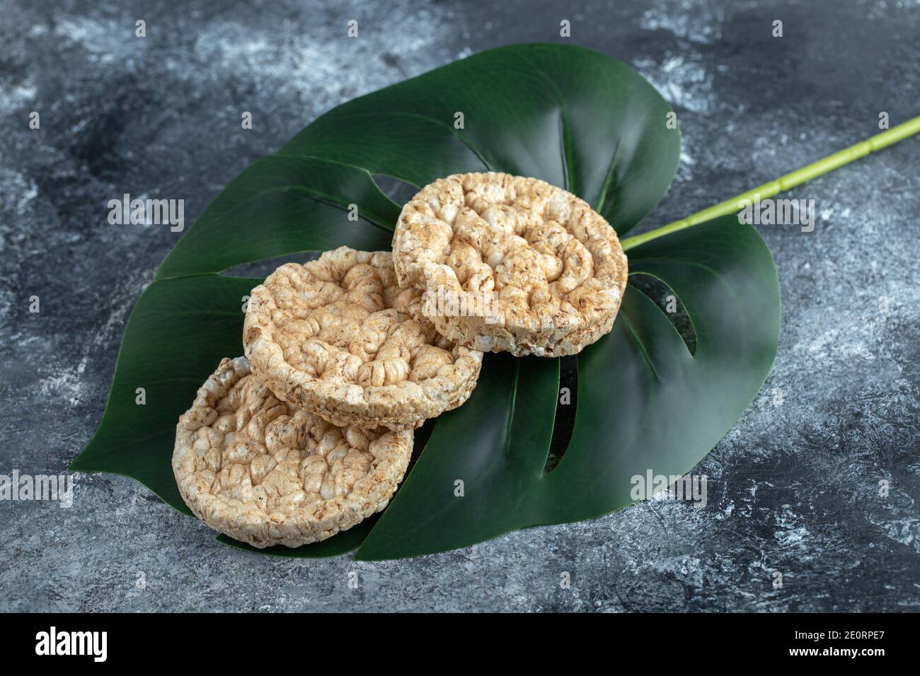 Leckere runde Knäckebrot auf grünen Blättern Stockfoto
