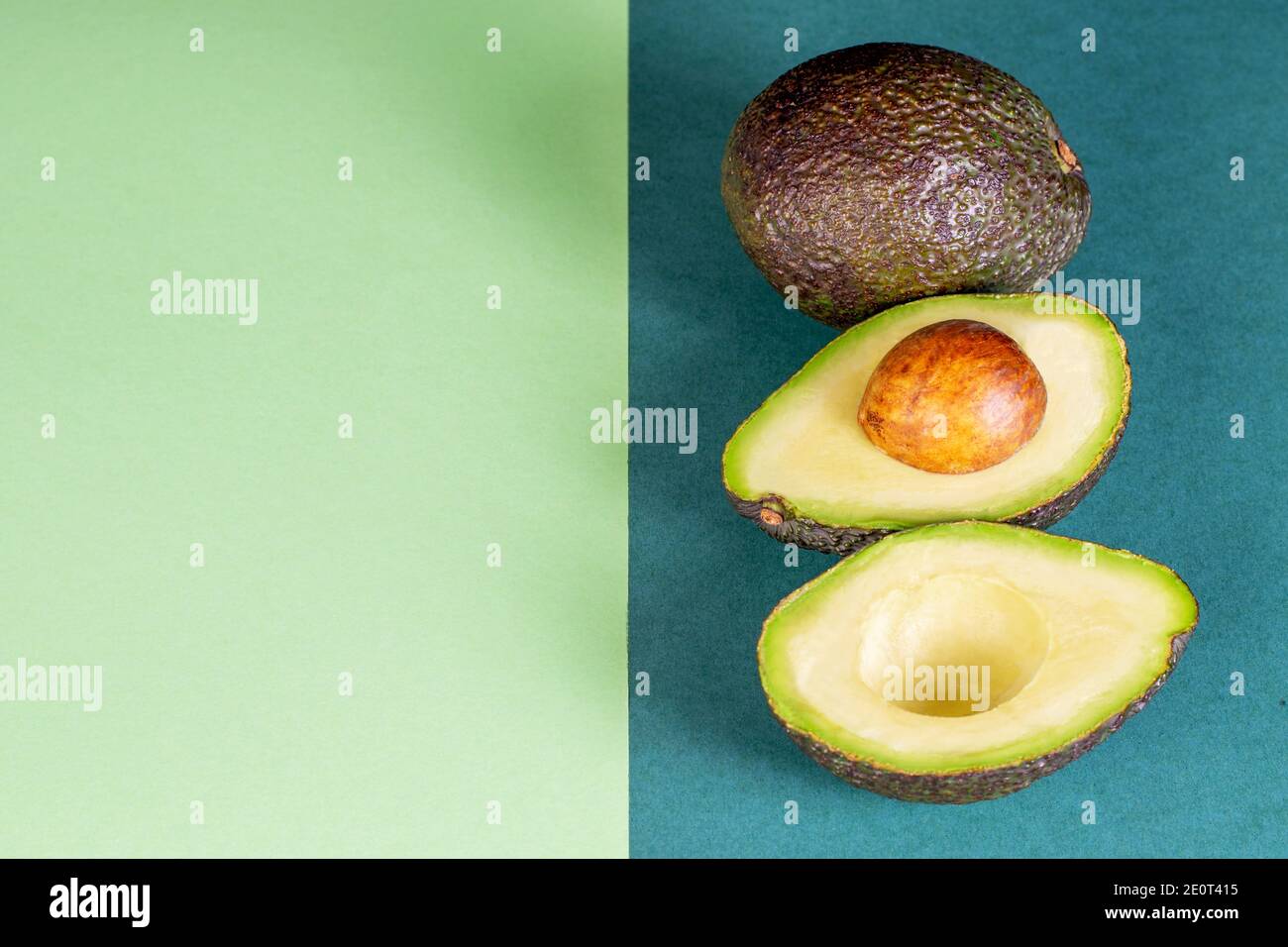 Vegetarische reife Avocado auf dem grünen Papier Hintergrund. Modell Foto, leer für Ihren Text. Stockfoto