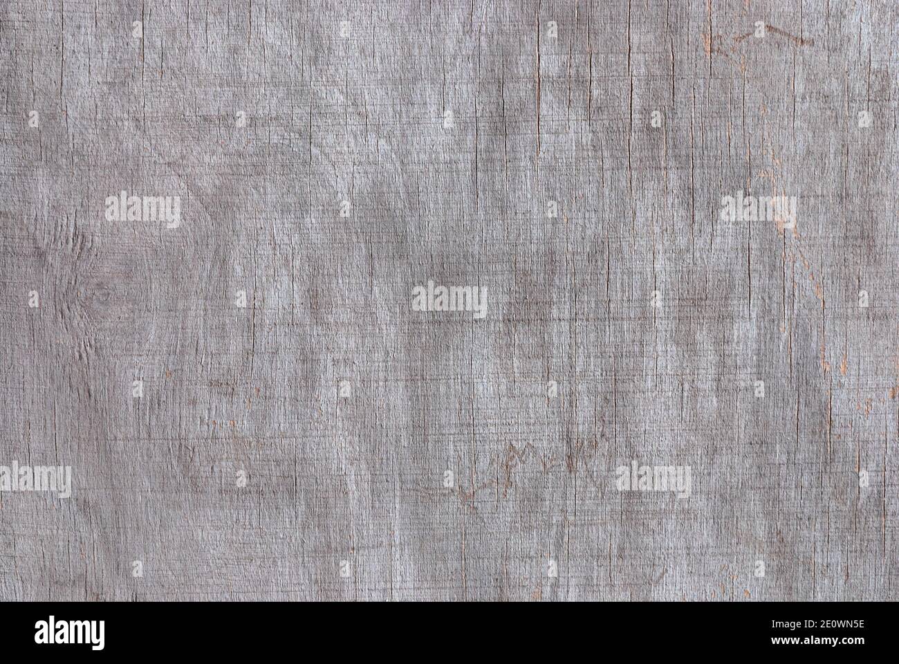 Textur aus grauem verblichenem Sperrholz mit Rissen, Streifen und Flecken von feuchtem und schlechtem Wetter Stockfoto