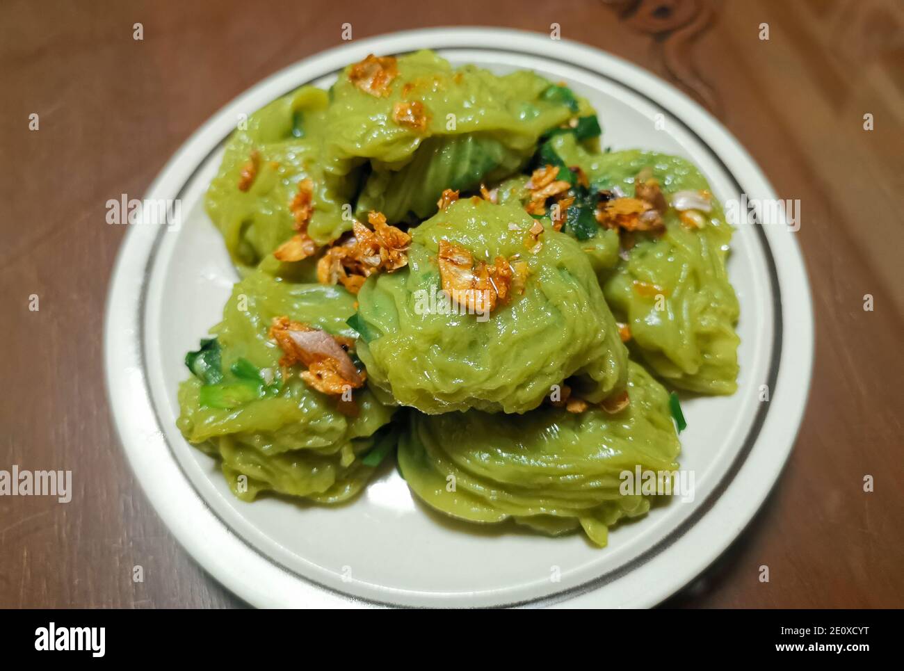 Chinesische Schnittlauch-Knödel, gebratener Schnittlauch, eingewickelt in dünnen Teig mit Pandan-Geschmack, bestreut mit gebratenem Knoblauch. Eine Art Snack in Thailand. Stockfoto