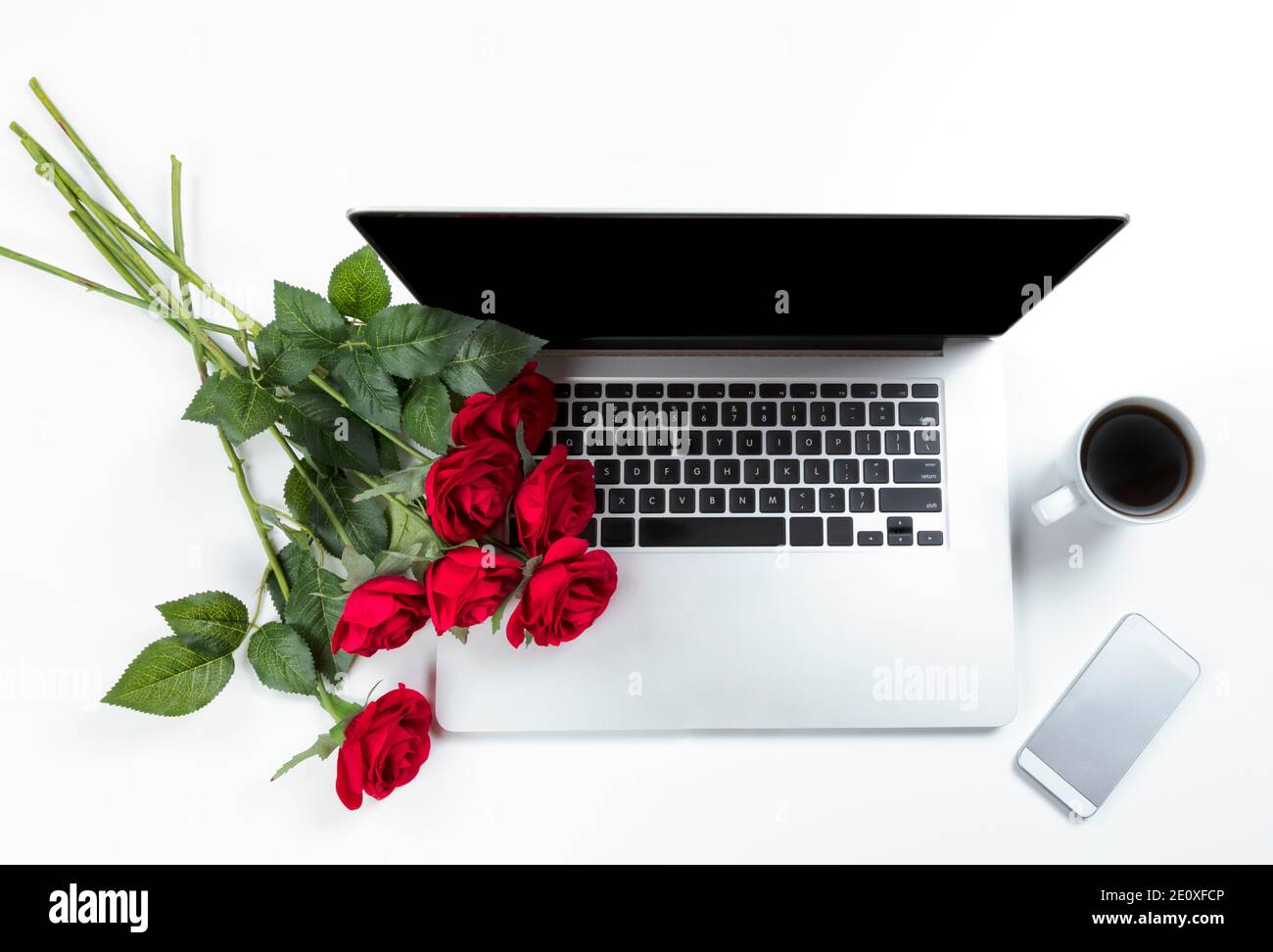 Rote Rosen auf Arbeitstisch für ein Liebesromantik-Konzept Wie Valentinstag Urlaub Stockfoto
