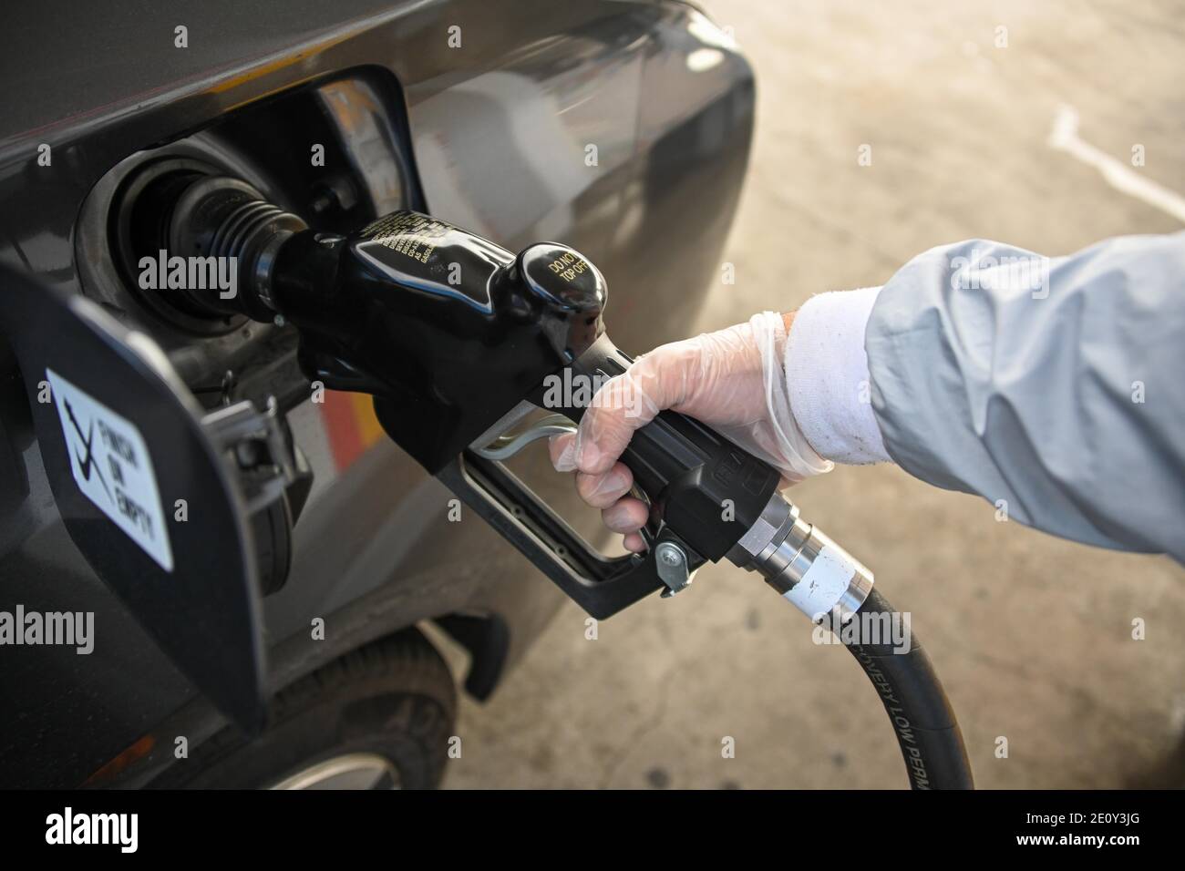 Dylan Stewart pumpt Gas, während er einen Gummihandschuh zum Schutz vor dem neuartigen Coronavirus verwendet, Montag, 28. Dezember 2020 in Barstow, Kalifornien (Dylan Stewart/IMAG Stockfoto