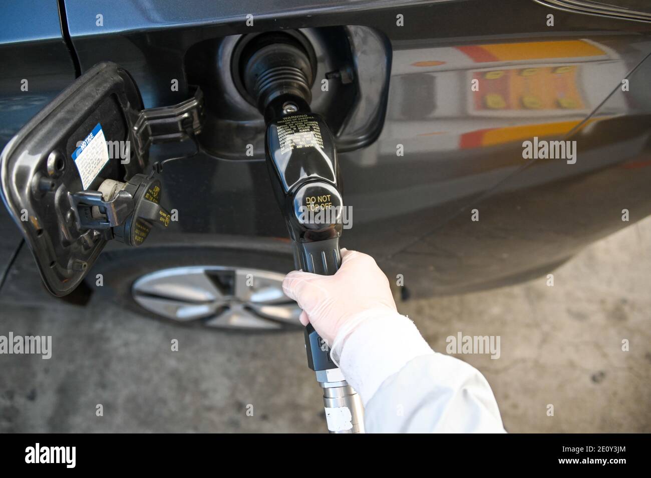 Dylan Stewart pumpt Gas, während er einen Gummihandschuh zum Schutz vor dem neuartigen Coronavirus verwendet, Montag, 28. Dezember 2020 in Barstow, Kalifornien (Dylan Stewart/IMAG Stockfoto