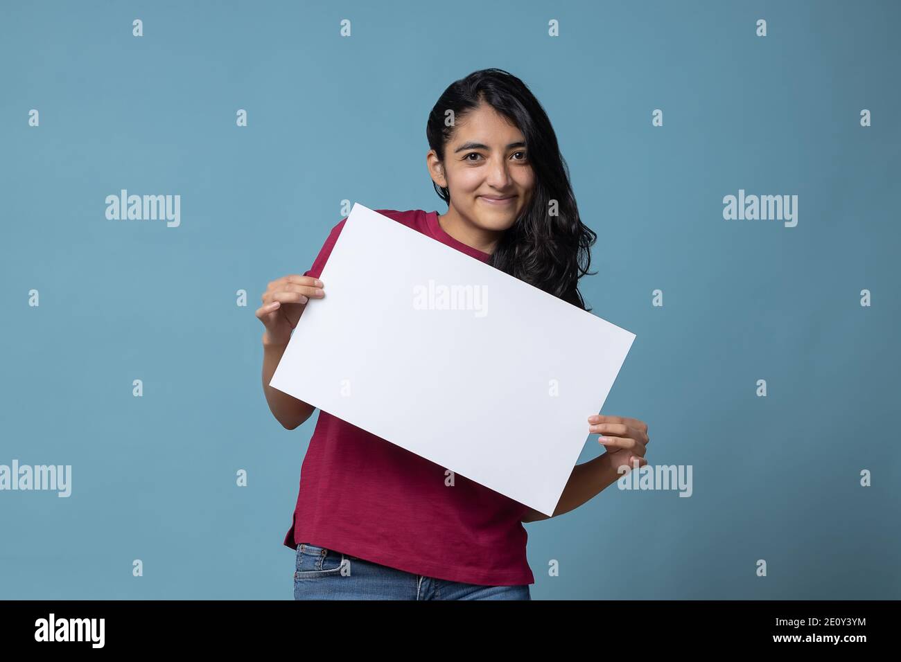 Mexikanische lateinische junge Erwachsene Frau hält einen leeren Frieden von Papier Stockfoto