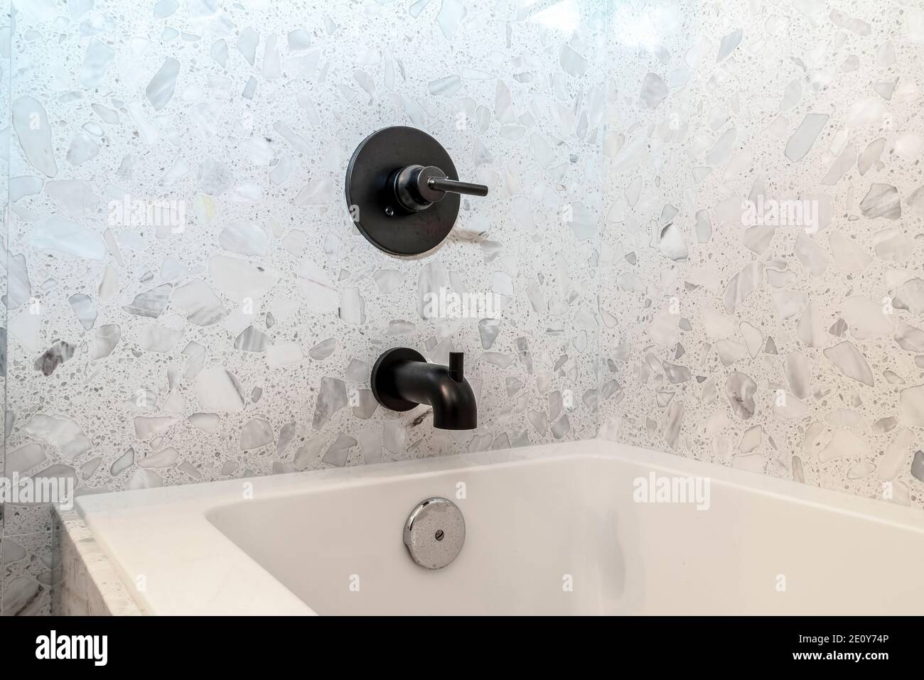 Minimalistisches Design im Badezimmer mit rechteckiger weißer eingebauter Badewanne Stockfoto