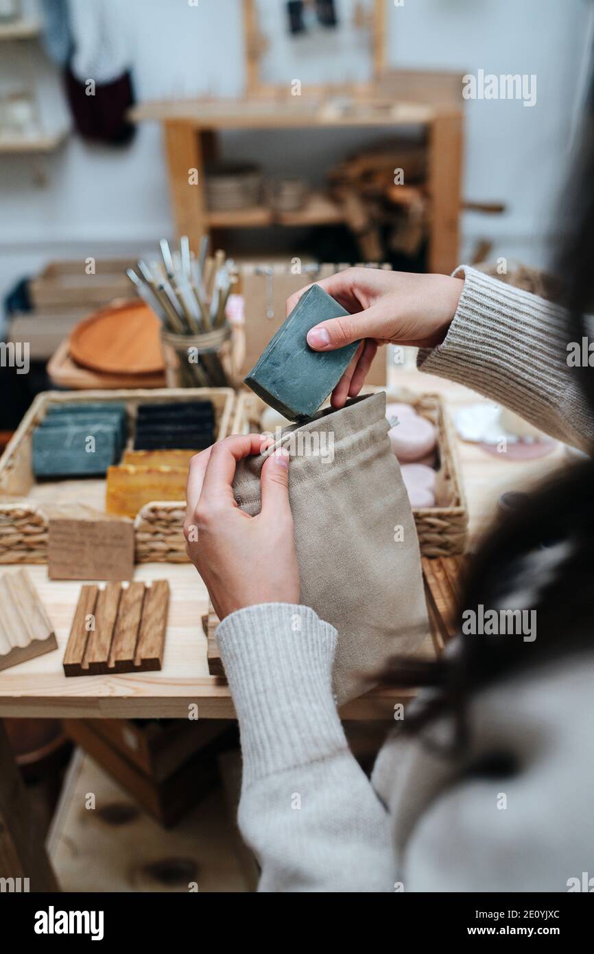 Frau Hände setzen Öko Seife in einem Stoffbeutel. Blick von hinten Schulter. Stockfoto
