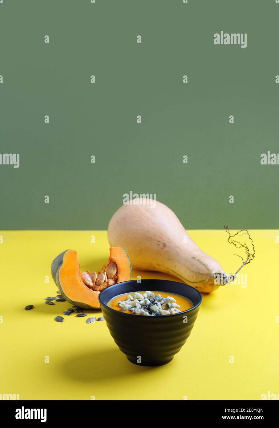 Kürbiscremesuppe mit einem Blauschimmelkäse, Kürbiskernen und rohen Kürbissen auf Dekoration. Warmes Essen und erster Gang der französischen Küche. Stockfoto
