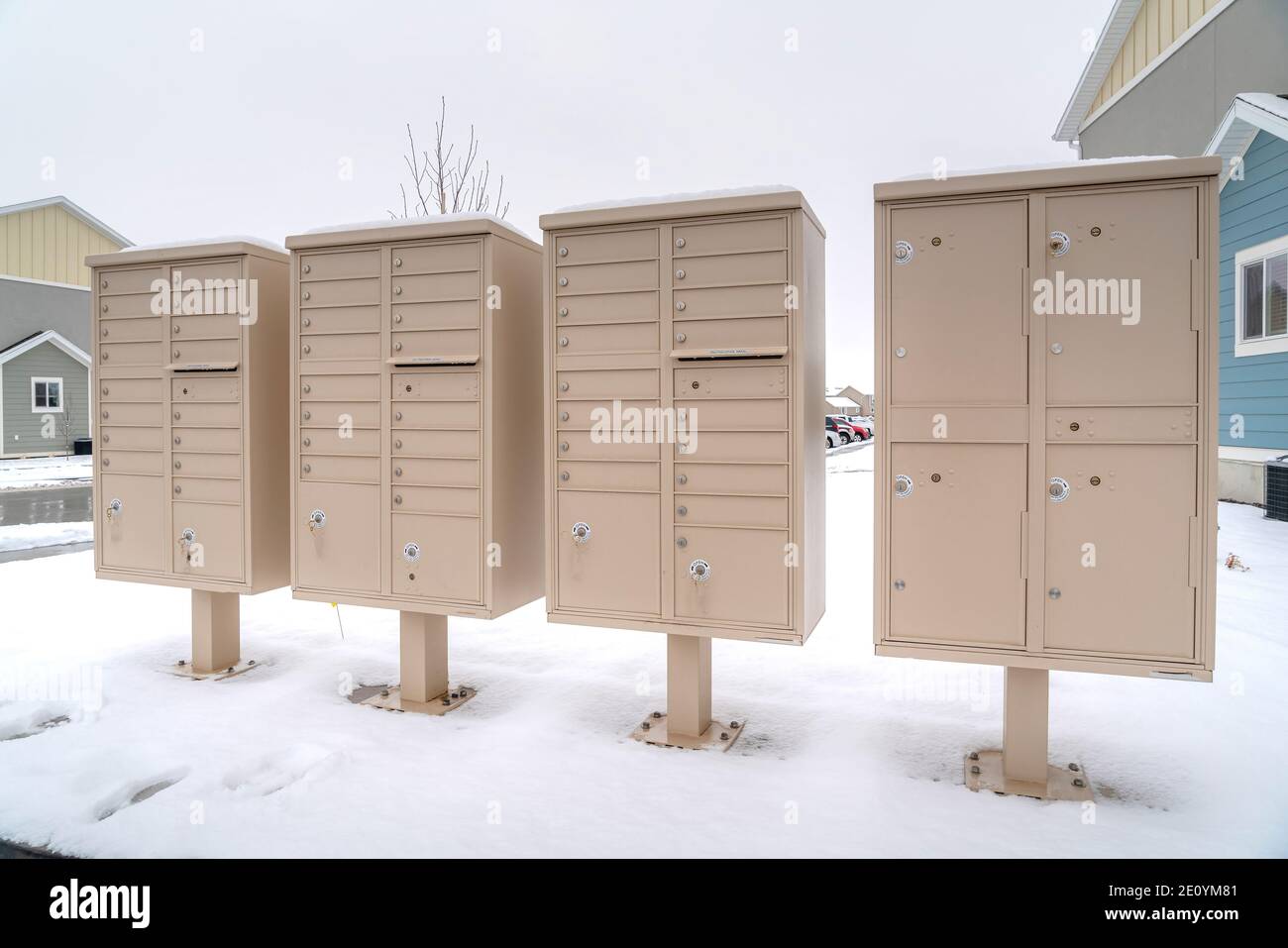Cluster-Mailboxen mit Fächern für Bewohner einer verschneiten Nachbarschaft Stockfoto