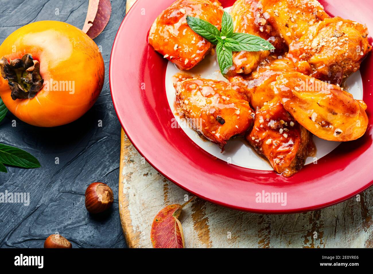 Stücke von karamellisiertem Persimmon.Delicious Caramel Persimmon auf dem Teller Stockfoto