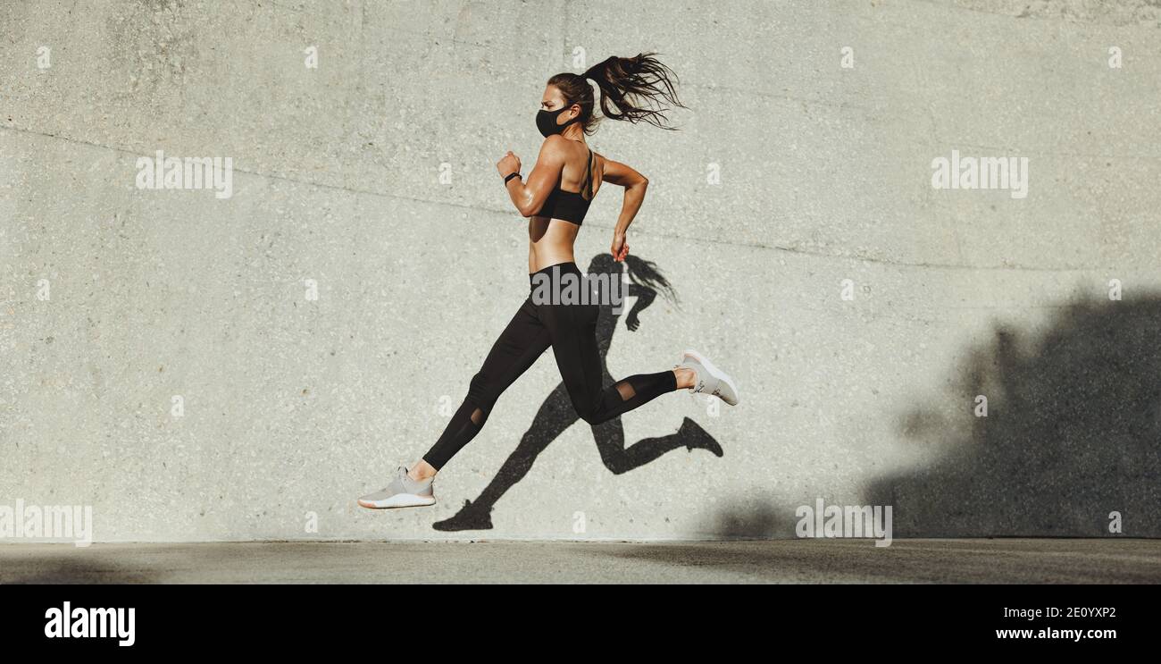 Fit Frau sprintet im Freien. Damen in Sportswear Running. Stockfoto