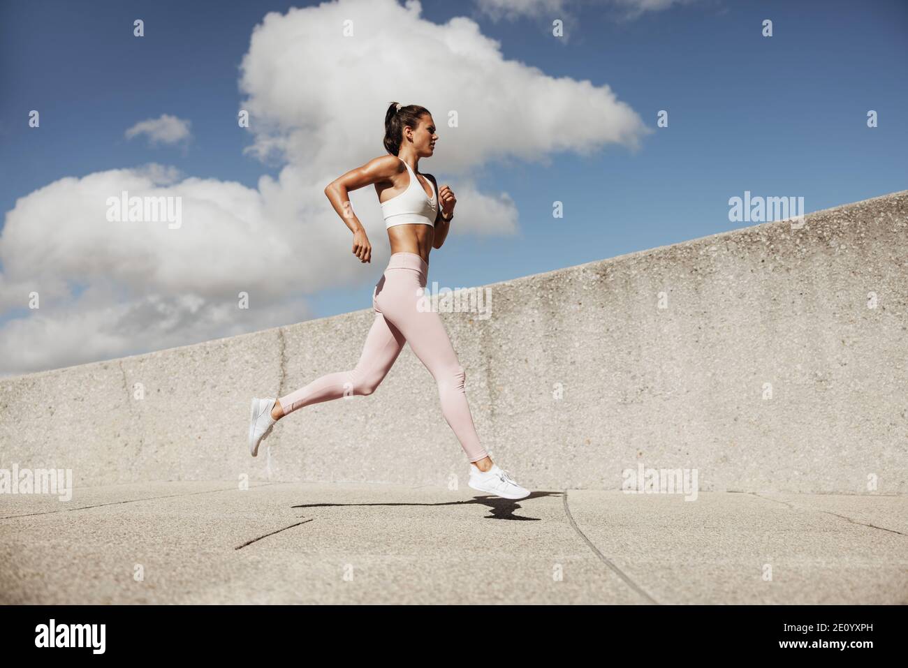 Frau in Sportswear Running. Frau Läuferin im Jogging-Outfit läuft im Freien. Stockfoto