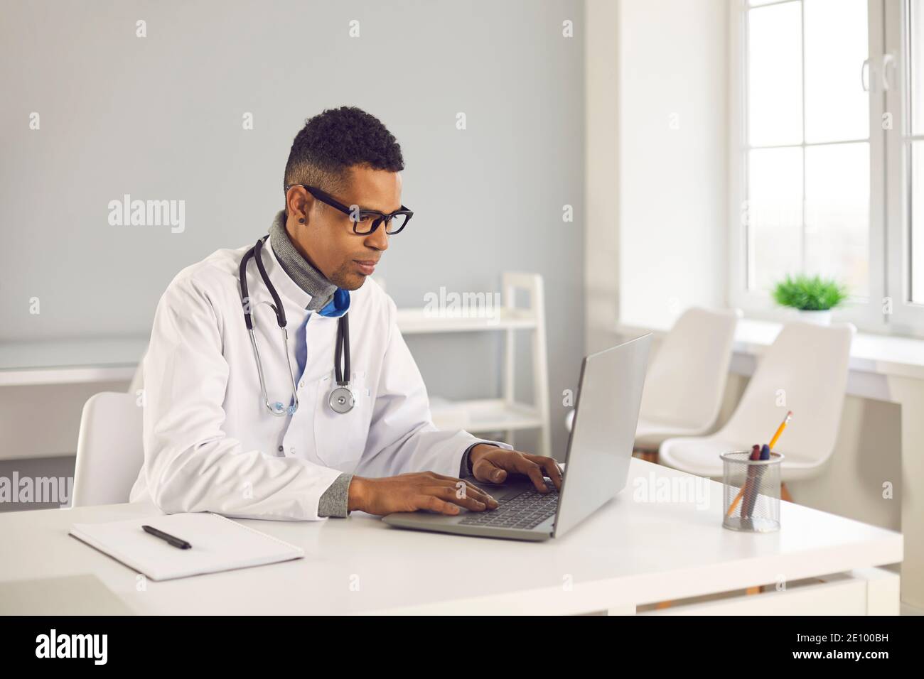 Arzt mit Laptop Online-Beratung zu geben oder zu füllen In elektronischen Gesundheitsakten Stockfoto