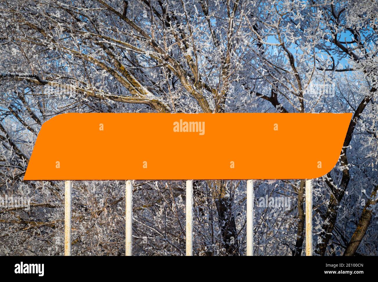 Großes orangefarbenes Schild vor der Kulisse verschneiter Bäume. Stockfoto