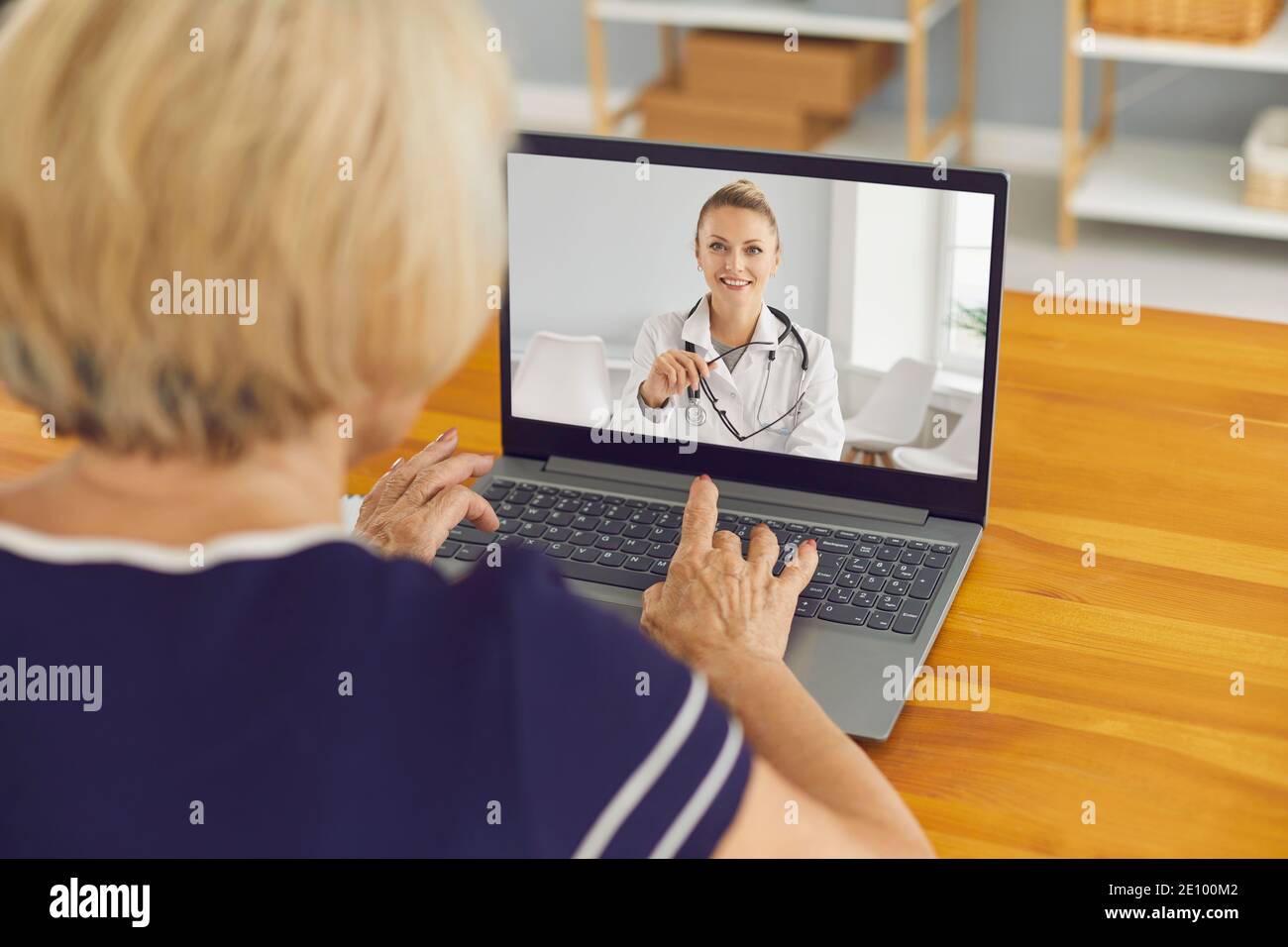 Ältere Frau sitzt am Laptop und im Gespräch mit virtuellen Arzt Des E-Health-Dienstes Stockfoto