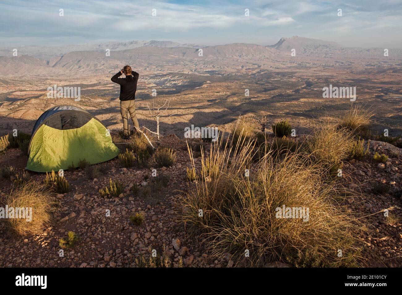 Der junge Mann betrachtet die Landschaft des Berges Jbel Bou Naceur in der Provinz Sedru von einem Plateau in der Nähe der Region Fez-Mequinez in seinem Lager Stockfoto