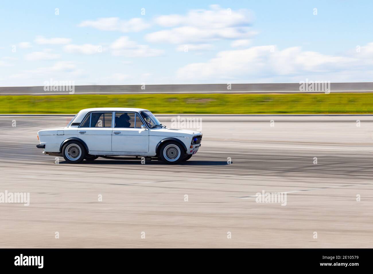 Chabarowsk, Russland - 23. Sep 2018: Ein weißes Shiguli-Auto driftet in einem offenen Bereich vor blauem Himmel und grünem Rasen. Rauch von unter dem wh Stockfoto