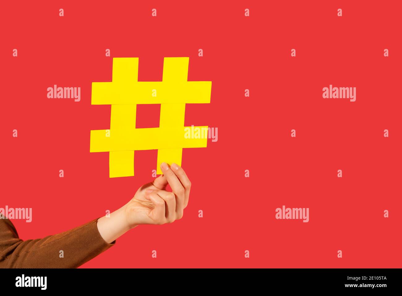 Treten Sie dem beliebten Blog bei! Nahaufnahme der weiblichen Hand mit großem gelben Hashtag Zeichen, teilen getaggte Nachricht, empfehlen folgen Trends. Innenaufnahmen im Studio Stockfoto