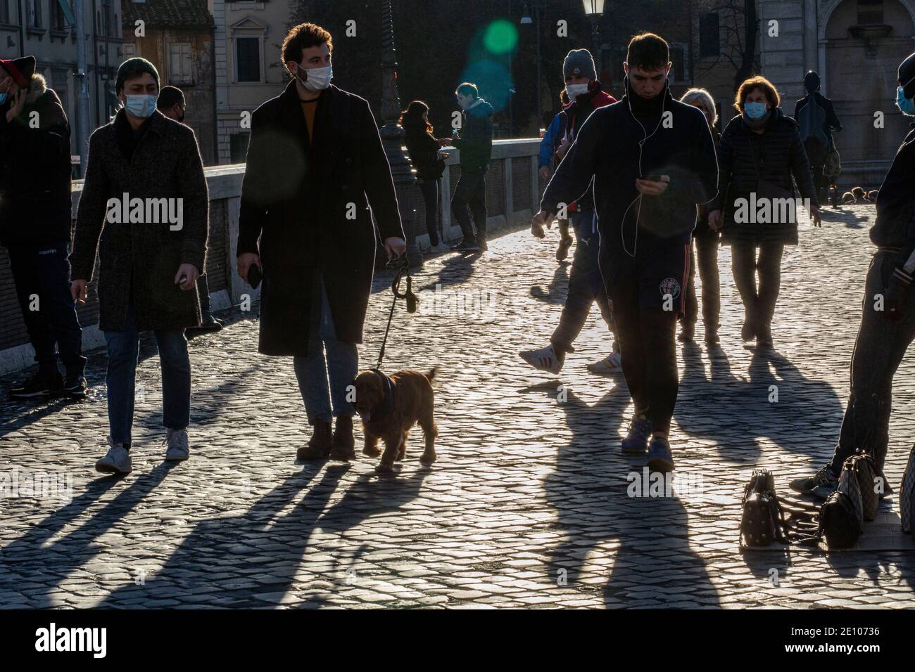 Trotz einer strengen Sperre an Ort und Stelle über die Neujahr vom 31. Dezember bis zum 3. Januar genießen die Leute Ein Spaziergang in der Sonne auf Ponte Sisto in Stockfoto