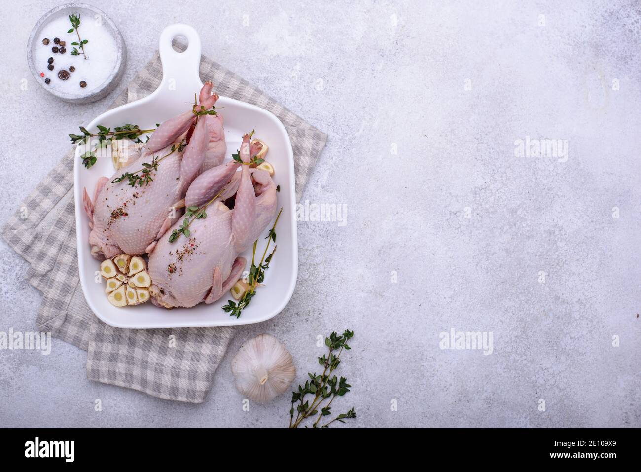 Rohes Wachtelfleisch mit Gewürzen, Knoblauch und Kräutern Stockfoto