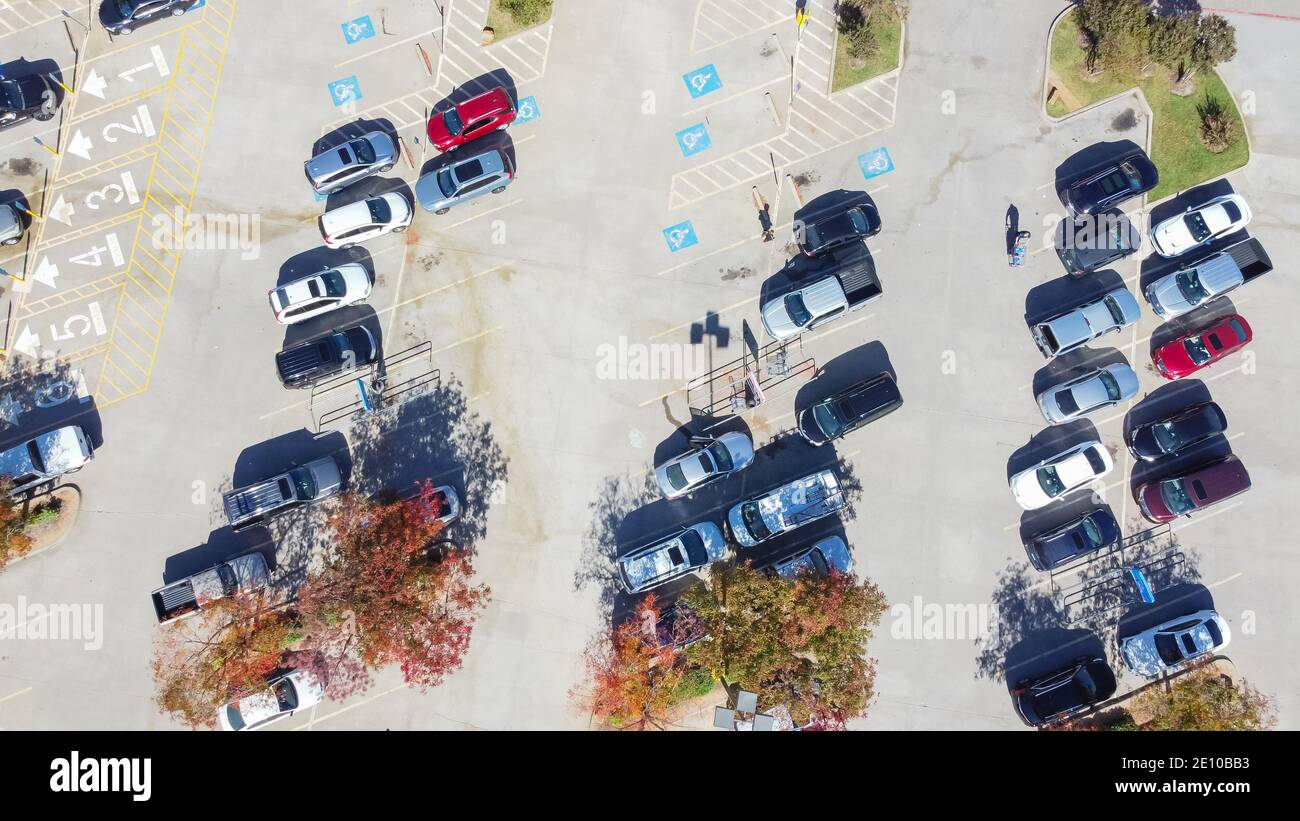 Draufsicht Menschen schieben Warenkorb auf Parkplatz des Lebensmittelladens in Vorort Dallas, Texas, Amerika. Sonniger Herbsttag mit buntem Herbstlaub Stockfoto