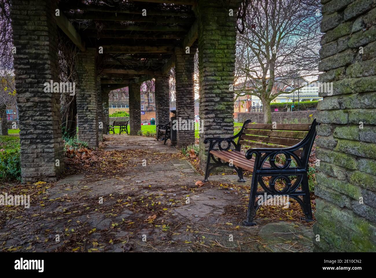 Ein überdachter Gehweg in einem Garten, Park, mit Bänken zum Ausruhen. Stockfoto
