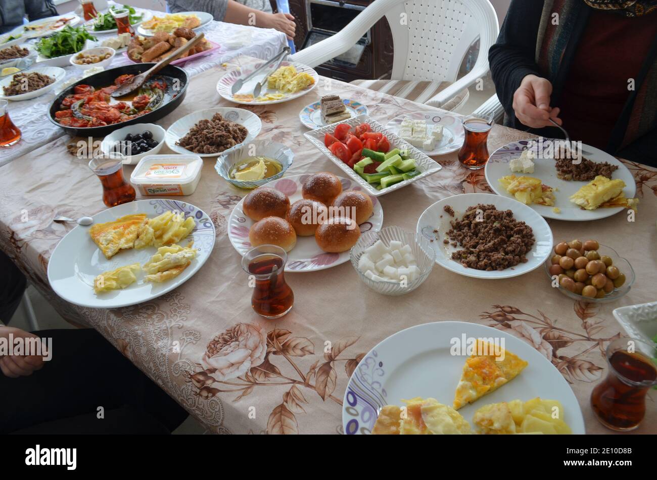 Türkisches Frühstück auf einem großen Tisch: Eier, Tee, Käse, Oliven, Gebäck, Fleisch Stockfoto