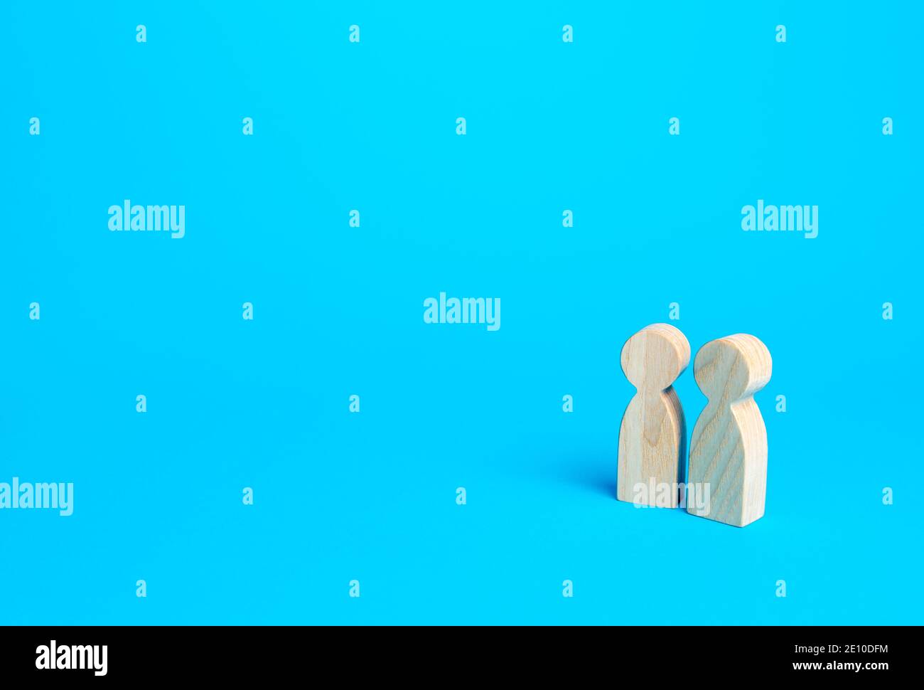Zwei Figuren von Menschen auf blauem Hintergrund. Kommunikation und Diskussion. Freundliche Beziehungen. Unterstützung, Zusammenarbeit und Zusammenarbeit. Ein Meeting. Pl Stockfoto