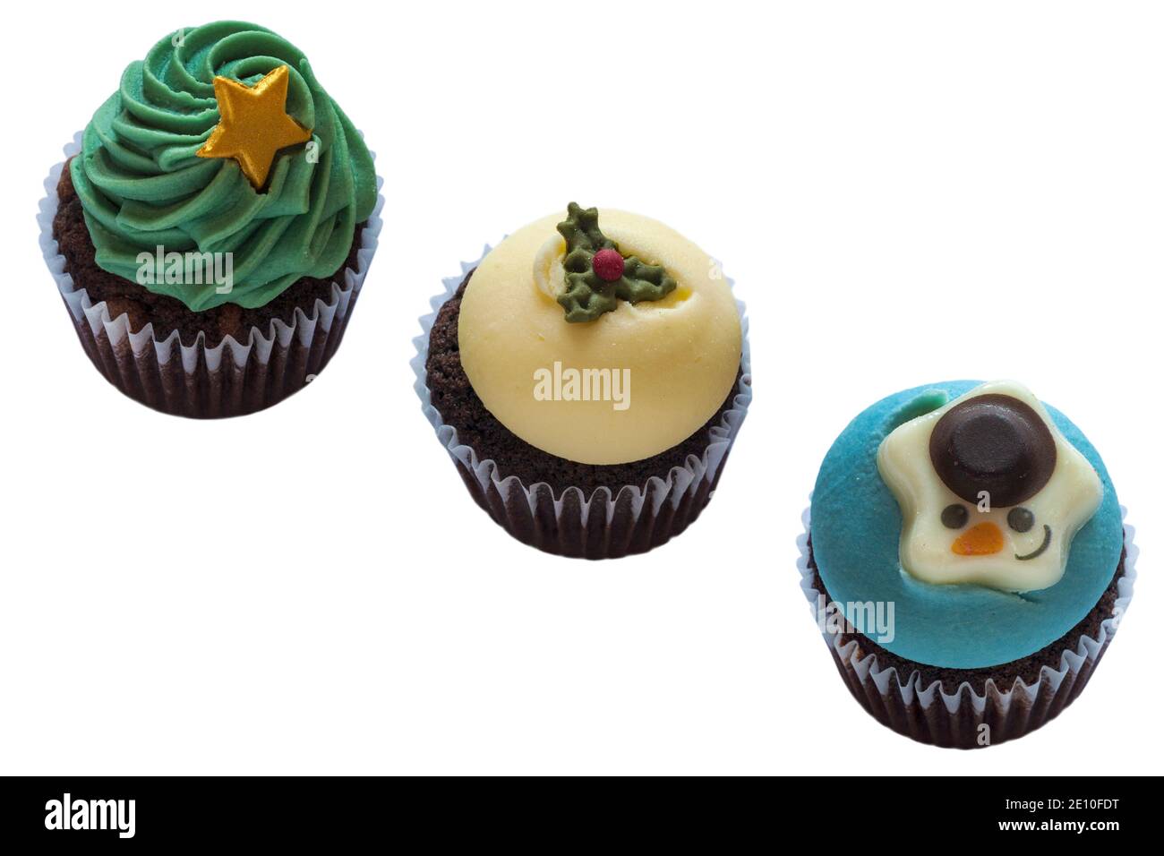 Weihnachtsbaum, Schneemann & Christmas Pudding Cupcakes Cup Cakes in einer Reihe, in einer Linie, M&S Mini festliche Cupcakes isoliert auf weißem Hintergrund Stockfoto