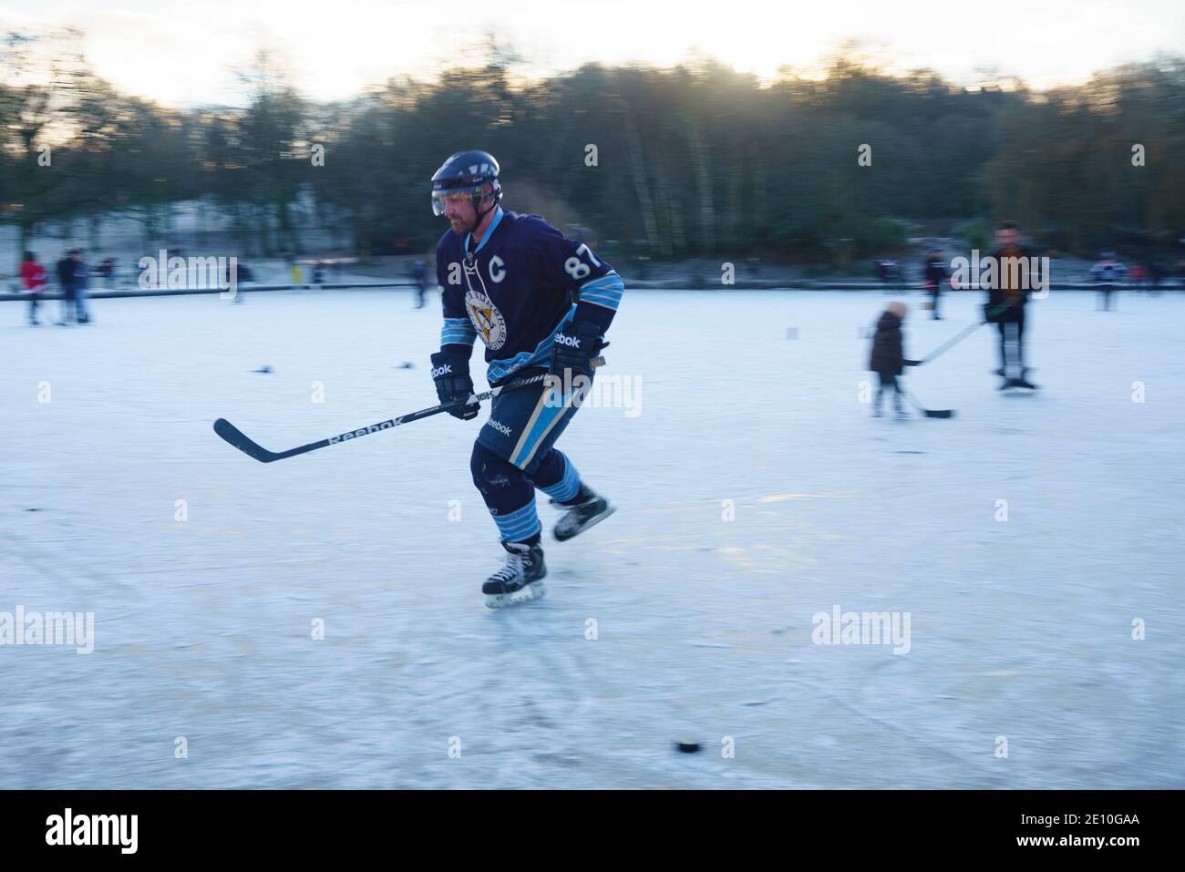 Glasgow, Schottland, Großbritannien. Januar 2021. Begeisterte Amateur-Eishockeyspieler und ein paar Eiskunstläufer nutzten heute Morgen die eisigen Temperaturen und einen seltenen gefrorenen Teich im Queens Park in Glasgow. Iain Masterton/Alamy Live News Stockfoto