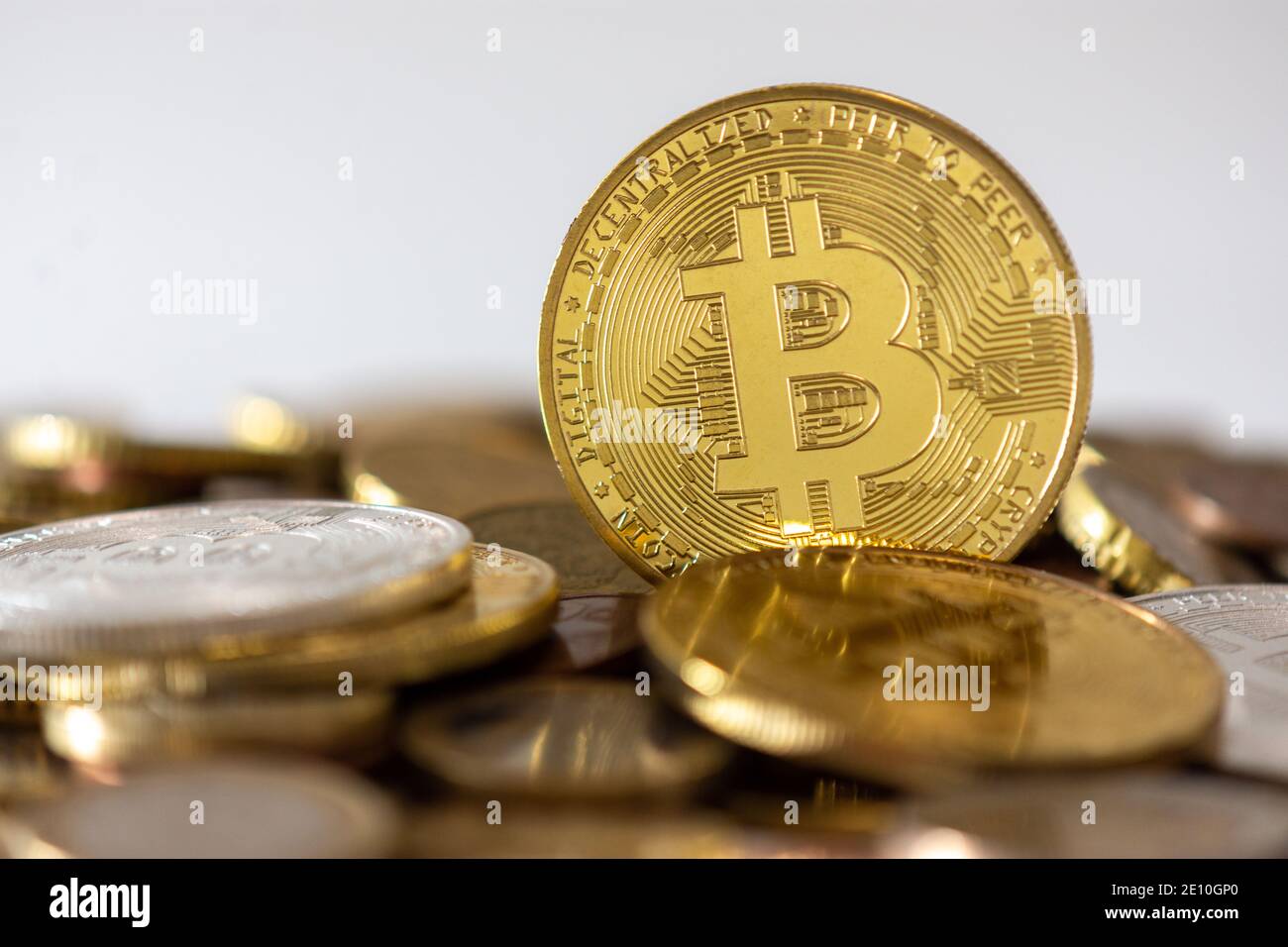 Eine goldene Bitcoin, die unter vielen verschwommenen Münzen steht. Bitcoin ist eine Kryptowährung, eine dezentrale digitale Währung ohne Zentralbank Stockfoto