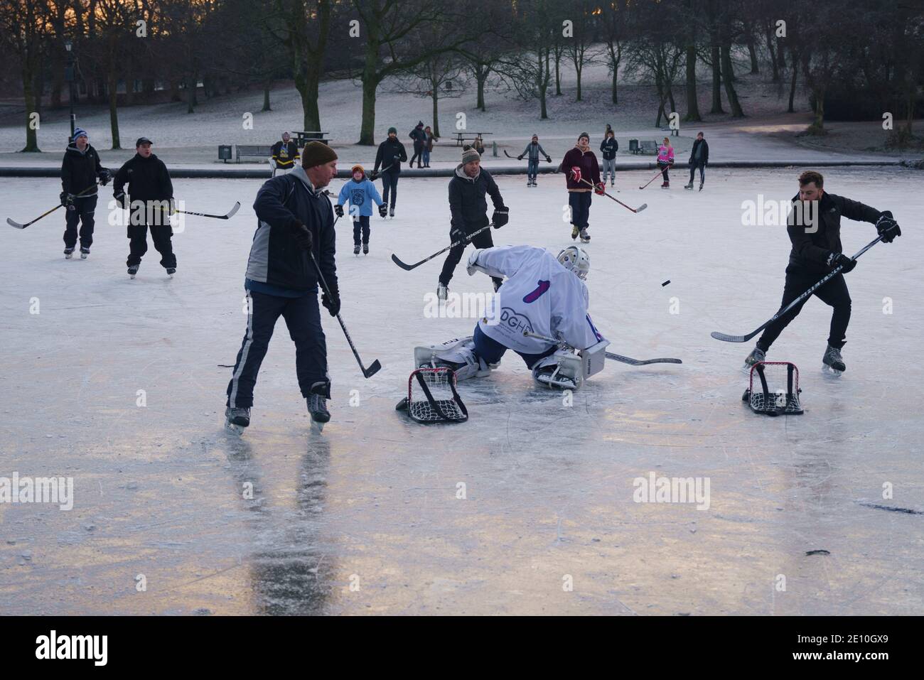 Glasgow, Schottland, Großbritannien. Januar 2021. Begeisterte Amateur-Eishockeyspieler und ein paar Eiskunstläufer nutzten heute Morgen die eisigen Temperaturen und einen seltenen gefrorenen Teich im Queens Park in Glasgow. Iain Masterton/Alamy Live News Stockfoto