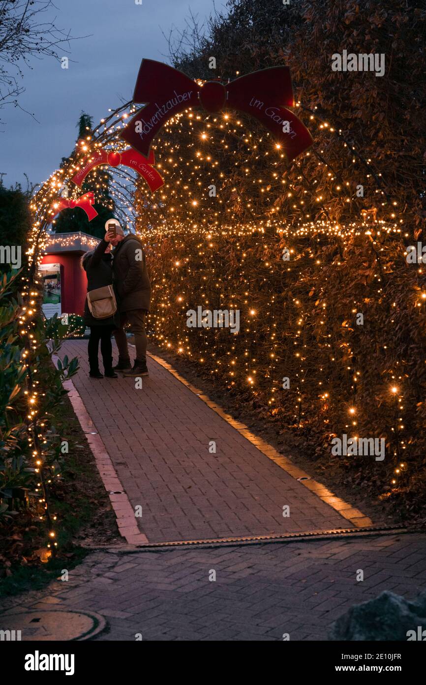 Ein Paar, das ein Selfie-Netz zu Weihnachtslichtern und Dekorationen in Kittenberger Erlebnisgärten macht, einem beliebten Touristenziel in Österreich Stockfoto