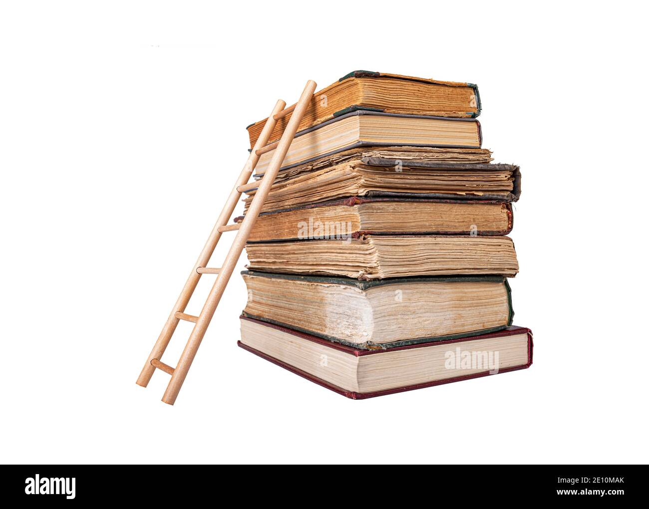 Stapel von alten Büchern und Holzleiter isoliert auf weißem Hintergrund. Stockfoto