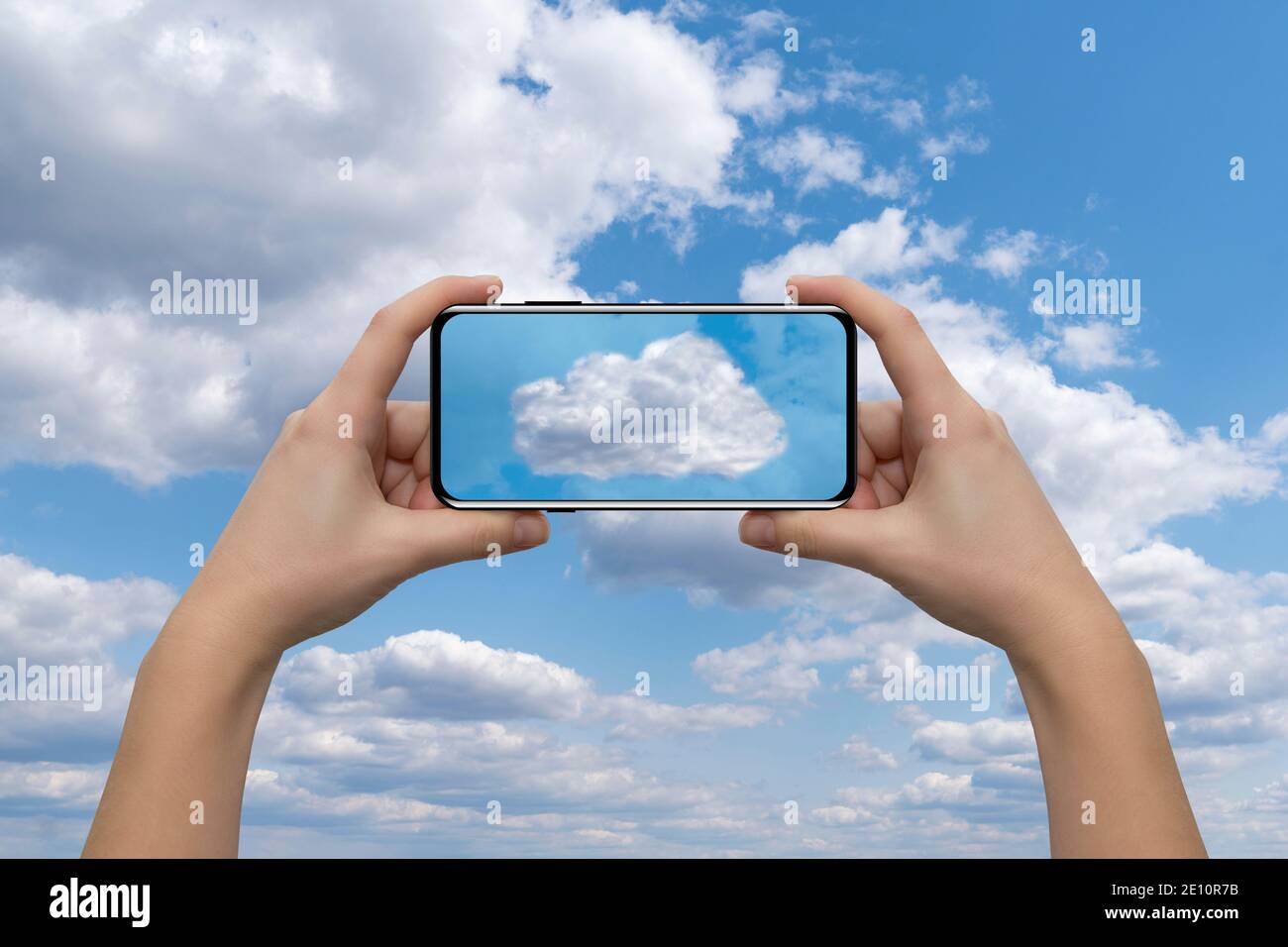 Hände mit Smartphone auf einem Hintergrund des blauen Himmels. Cloud-Service-Idee Stockfoto