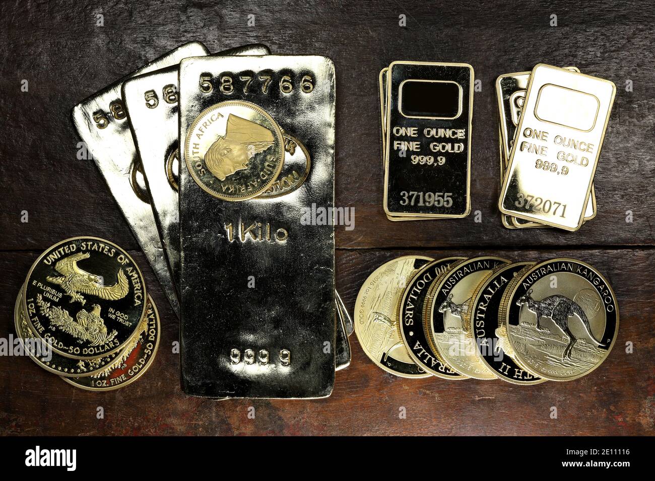 Goldbarren eine Vielzahl von Anlagemünzen auf Holzhintergrund Stockfoto