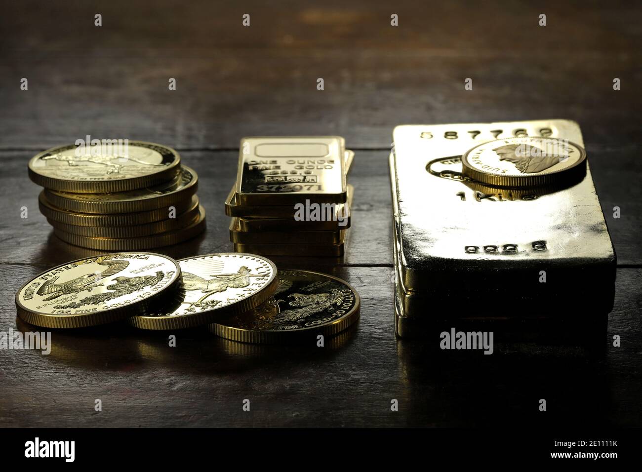 Goldbarren eine Vielzahl von Anlagemünzen auf Holzhintergrund Stockfoto