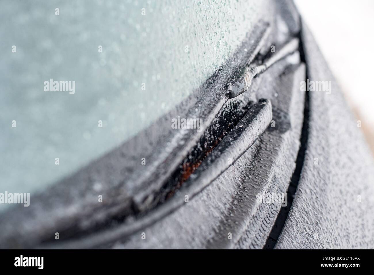 Nahaufnahme der Scheibenwischer und der mit Eis bedeckten, mattierten Autoscheibe Bei geringer Schärfentiefe Stockfoto