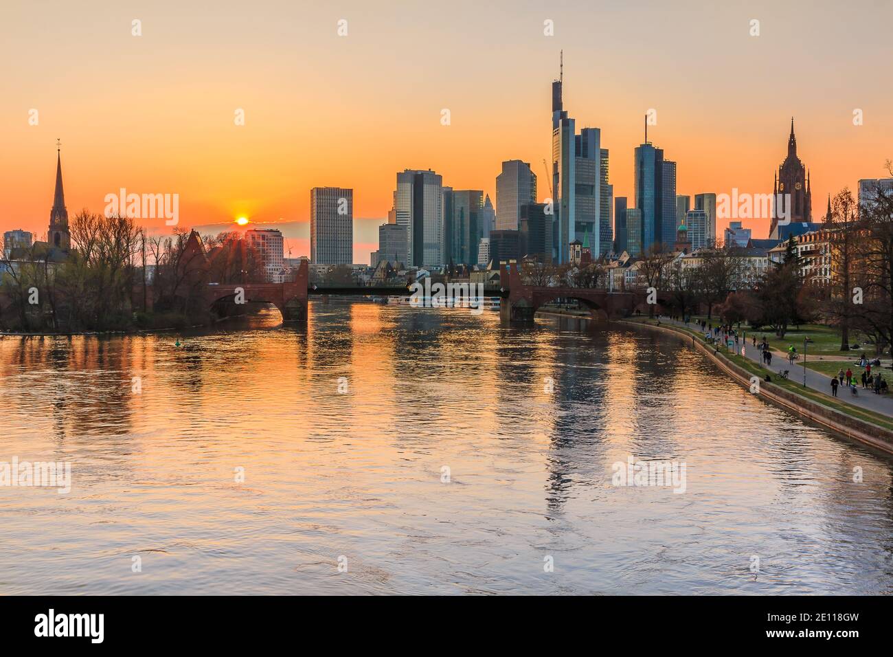 Frankfurter Skyline am Abend bei Sonnenuntergang. Fluss Main Reflexionen der Wolkenkratzer. Finanz- und Geschäftsviertel im Zentrum der Stadt. Parken Stockfoto
