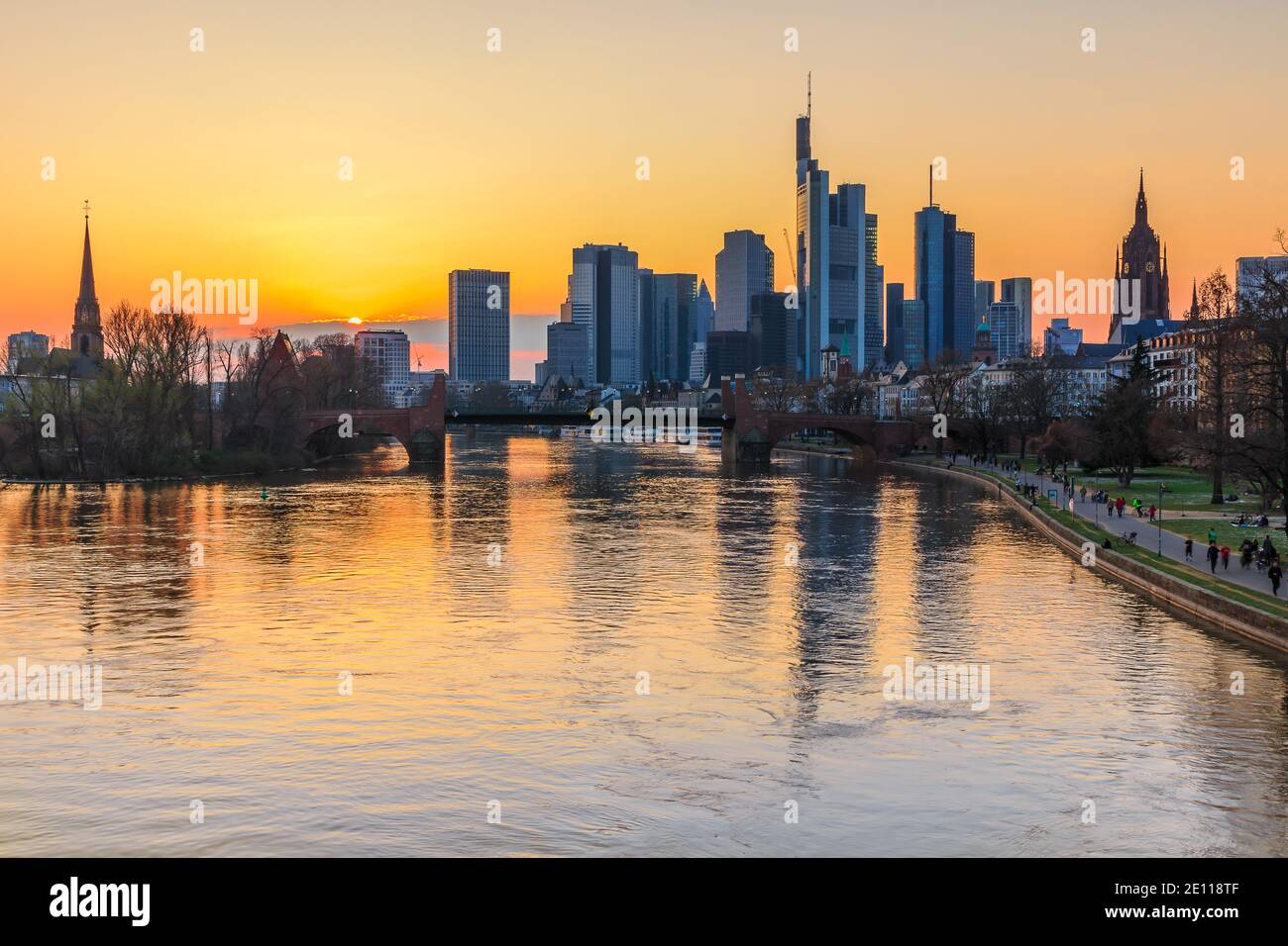 Frankfurter Skyline am Abend bei Sonnenuntergang. Fluss mit Reflexionen im Wasser des Wolkenkratzers. Finanz- und Geschäftsviertel im Zentrum von Th Stockfoto