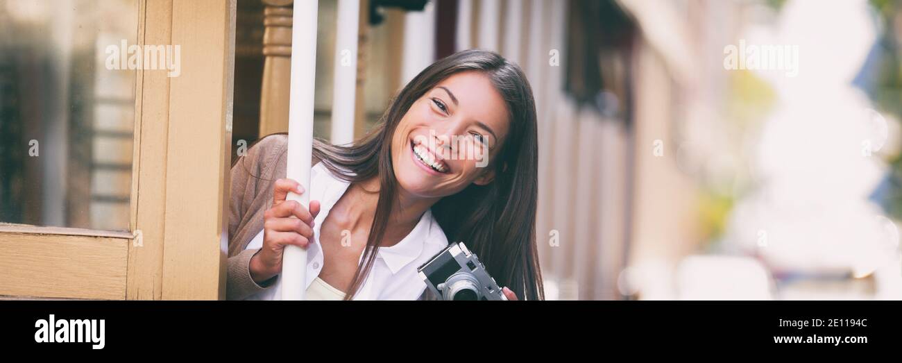 Lächelnde asiatische Frau, die Fotos auf Trolley Straße Auto Fahrt mit Vintage-Kamera Panorama-Banner. Touristen fahren öffentliche Verkehrsmittel Straßenbahn-System in Stockfoto