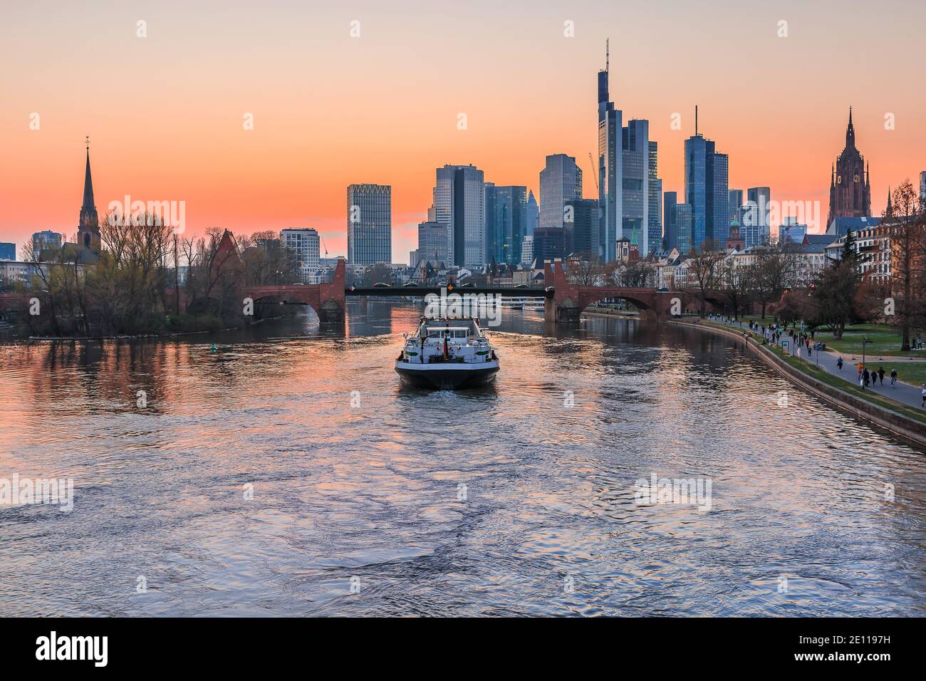 Das Finanz- und Geschäftszentrum von Frankfurt. Skyline der Stadt am Abend bei Sonnenuntergang mit Main. Park am Ufer des Flusses. Schiff auf dem Rive Stockfoto