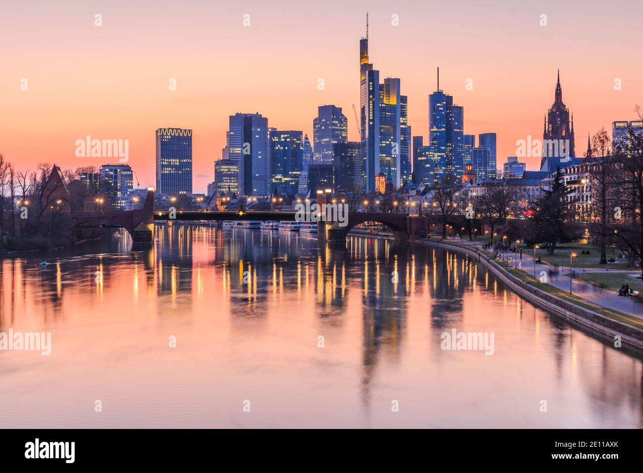 Frankfurter Skyline am Abend. Geschäftshäuser aus dem Finanzviertel mit Lichtern und Reflexen im Mainwasser Stockfoto