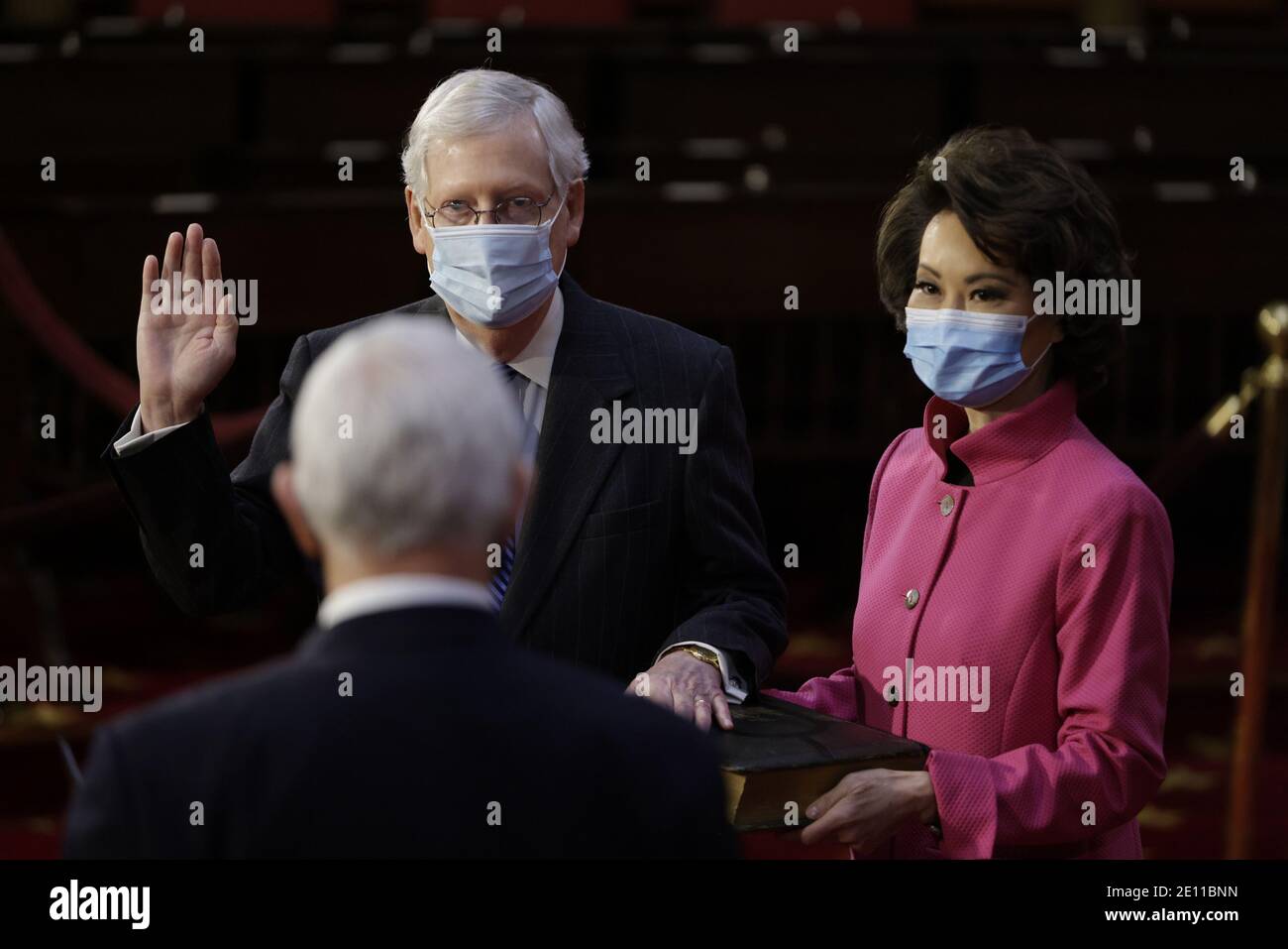Der Mehrheitsführer des Senats Mitch McConnell, ein Republikaner aus Kentucky, links, trägt eine Schutzmaske, während er am Sonntag, dem 3. Januar 2021, von US-Vizepräsident Mike Pence, unten links, mit Elaine Chao, US-Verkehrsministerin, rechts, im US-Kapitol in Washington, DC feierlich vereidigt wird. Der 117. Kongress beginnt heute mit der Wahl des Sprechers des Hauses und der Verwaltung des Amtseids für die Gesetzgeber in beiden Kammern, Verfahren, die geändert werden, um für Covid-19 Vorsichtsmaßnahmen Rechnung zu tragen. Poolfoto Samuel Corum/UPI Stockfoto