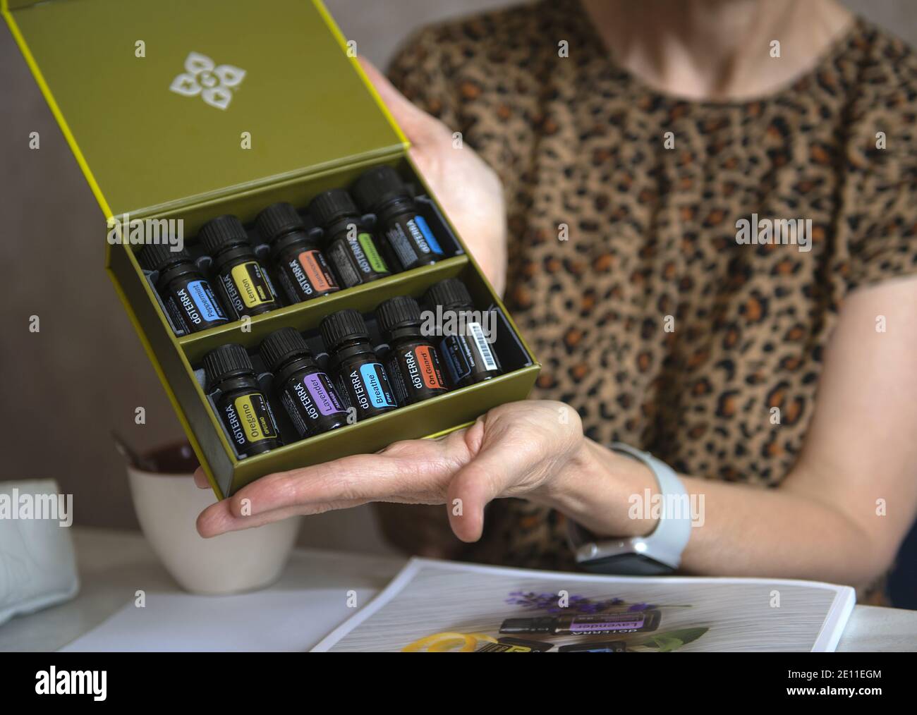 Doterra ätherische Ölflaschen. Ätherisches Öl. Ätherisches doterra-Öl. Yoga-Kurs. Ätherische Öle in den Händen einer Frau. Frauenhände mit Ölflasche Stockfoto
