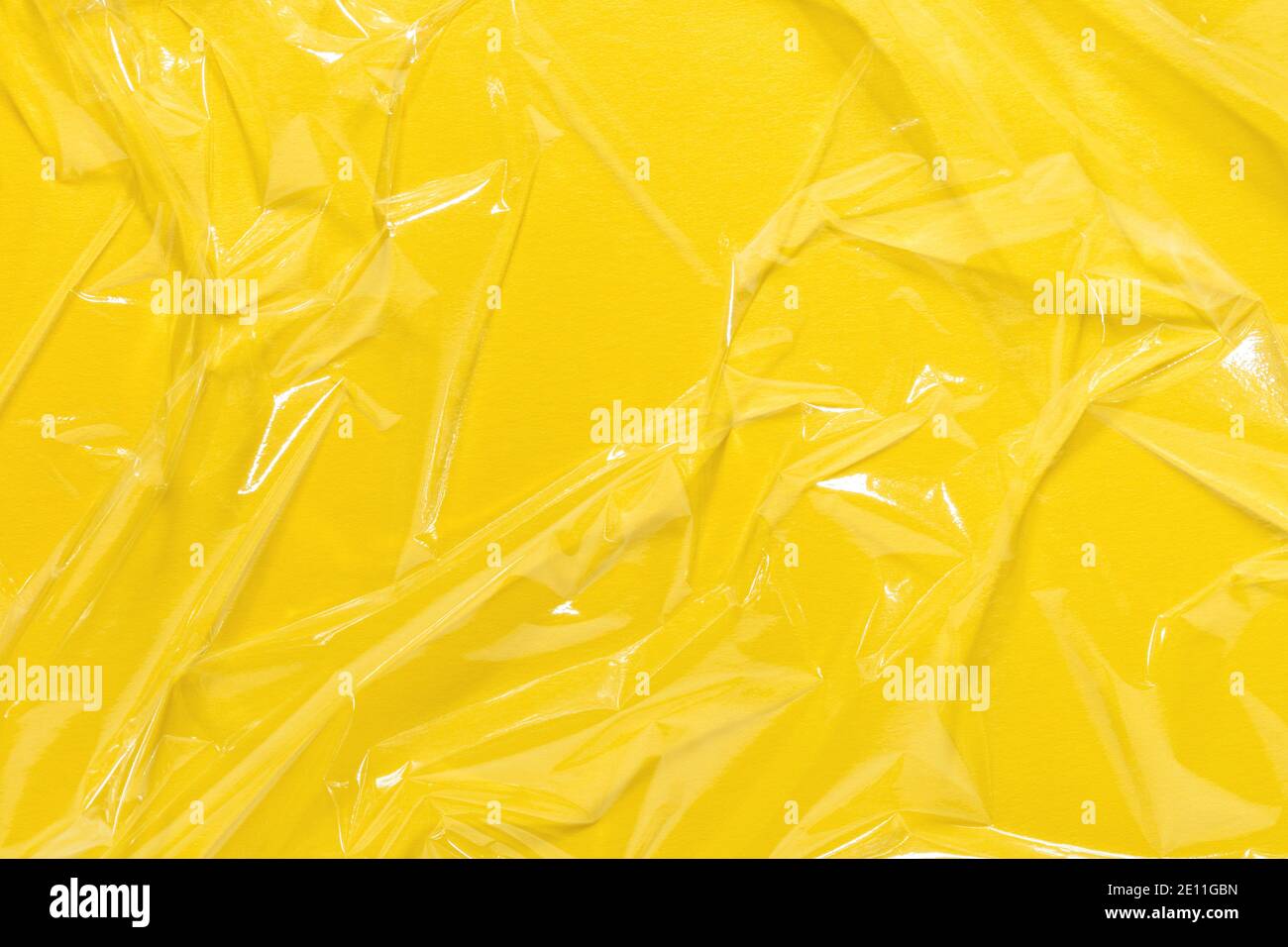 Zerknittert Frischhaltefolie, Kunststoff-Textur, Vinyl gelb Kunst Hintergrund. Stockfoto