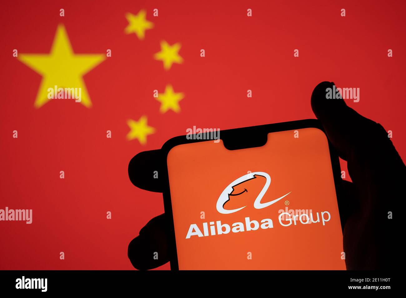 Stafford, Großbritannien - 3. Januar 2021: Alibaba-Logo auf einer Silhouette des Smartphones fest in der Hand halten. Konzept für die Regierung und den Tech-Giganten. Stockfoto