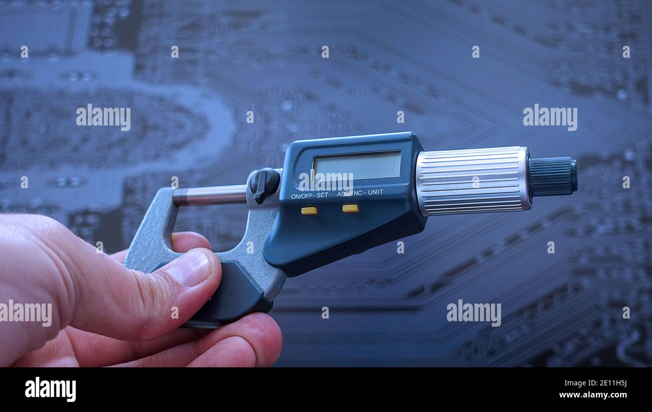 Еnegineer Arbeiten mit einem präzisen Mikrometer mit digitaler Anzeige zur Qualitätskontrolle. Nahaufnahme des horizontalen Videos des genauen Messgeräts. Stockfoto